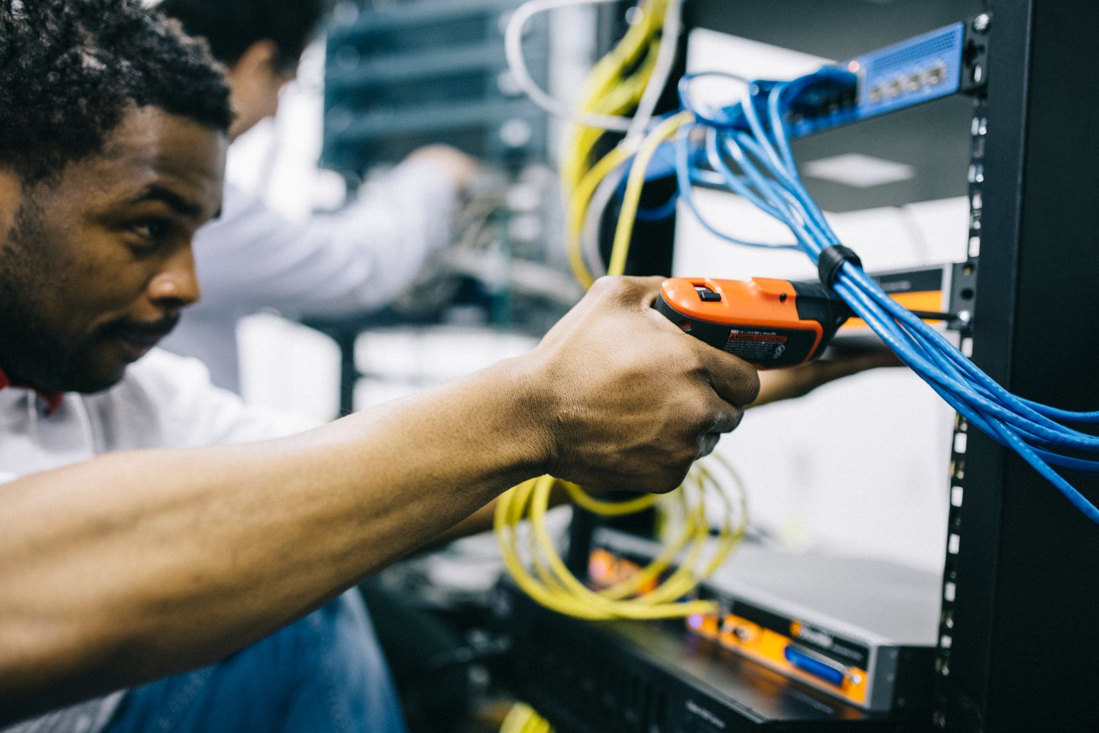 IT engineer connecting network cables in a server rack